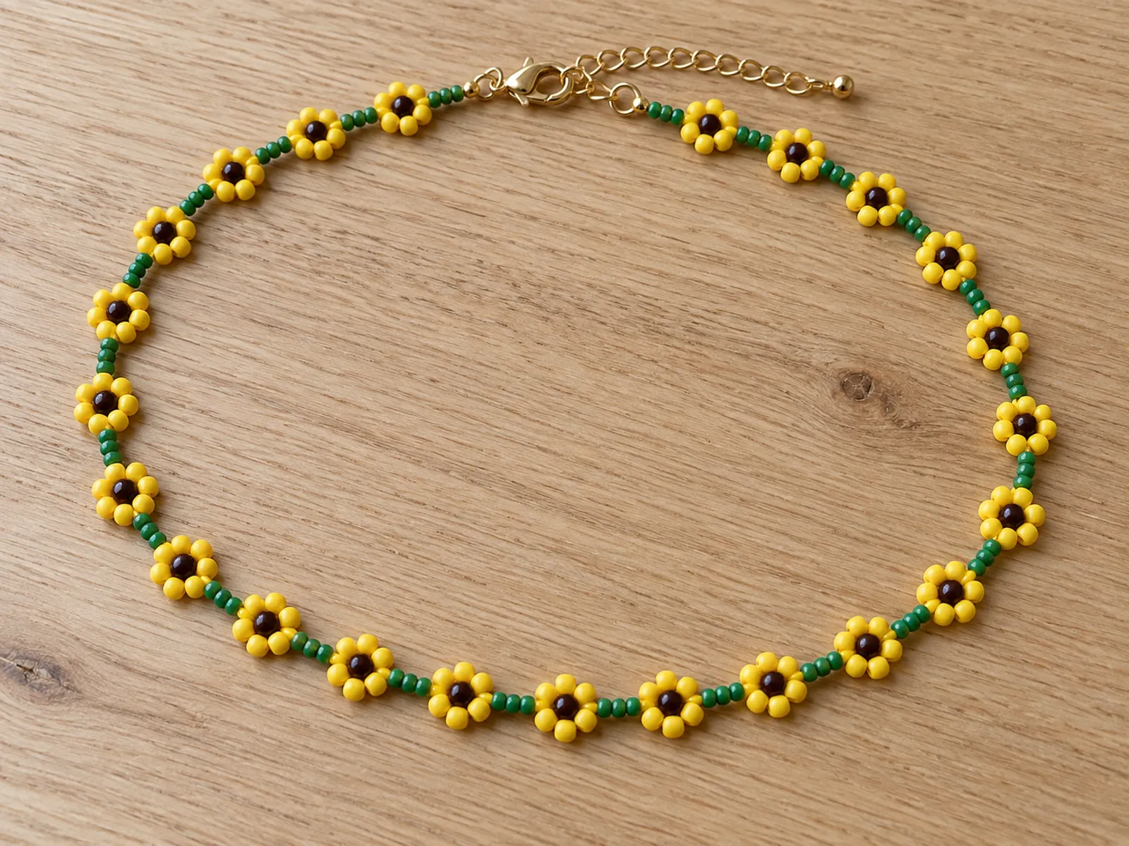 KI-generiertes Bild: fertiger Sonnenblumen-Choker aus gelben, braunen und grünen Rocailles auf hellem Holztisch